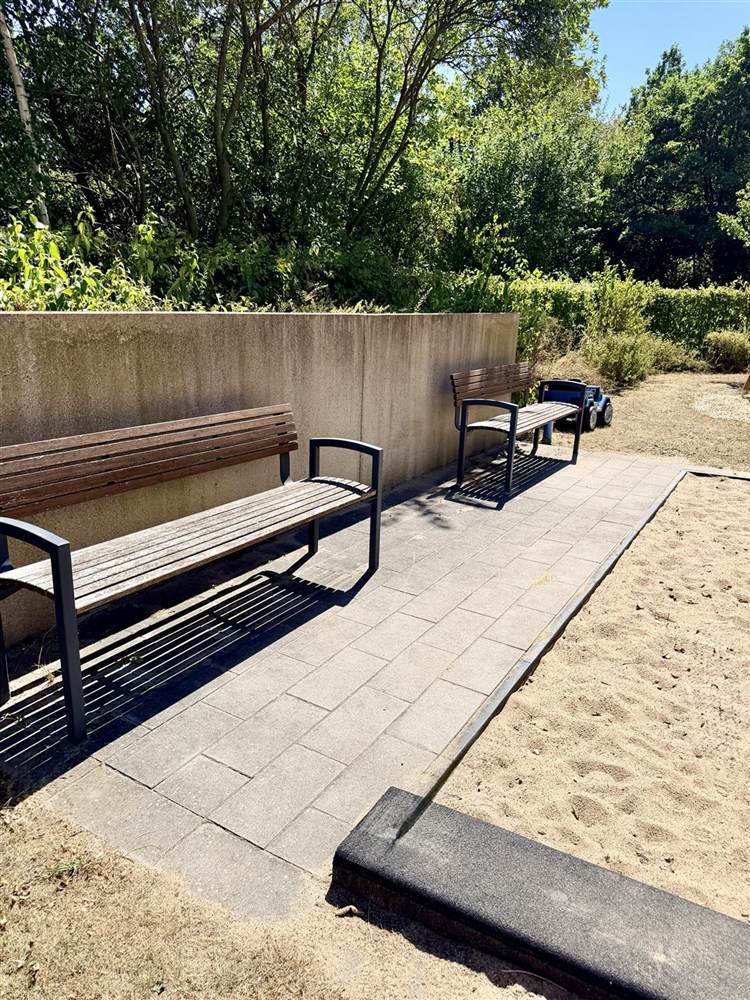 Spielplatz mit Bänken und Sandkasten einer Wohnanlage